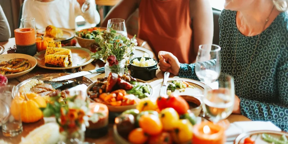 diverse group enjoying a festive meal at a food-filled table