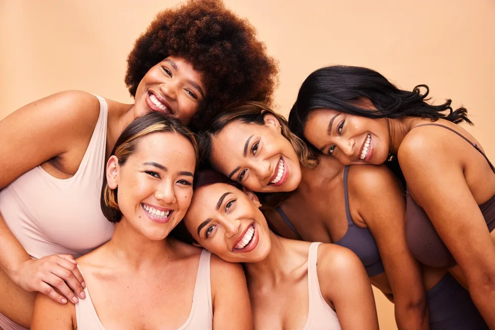 diverse women smiling with makeup on their faces celebrating beauty