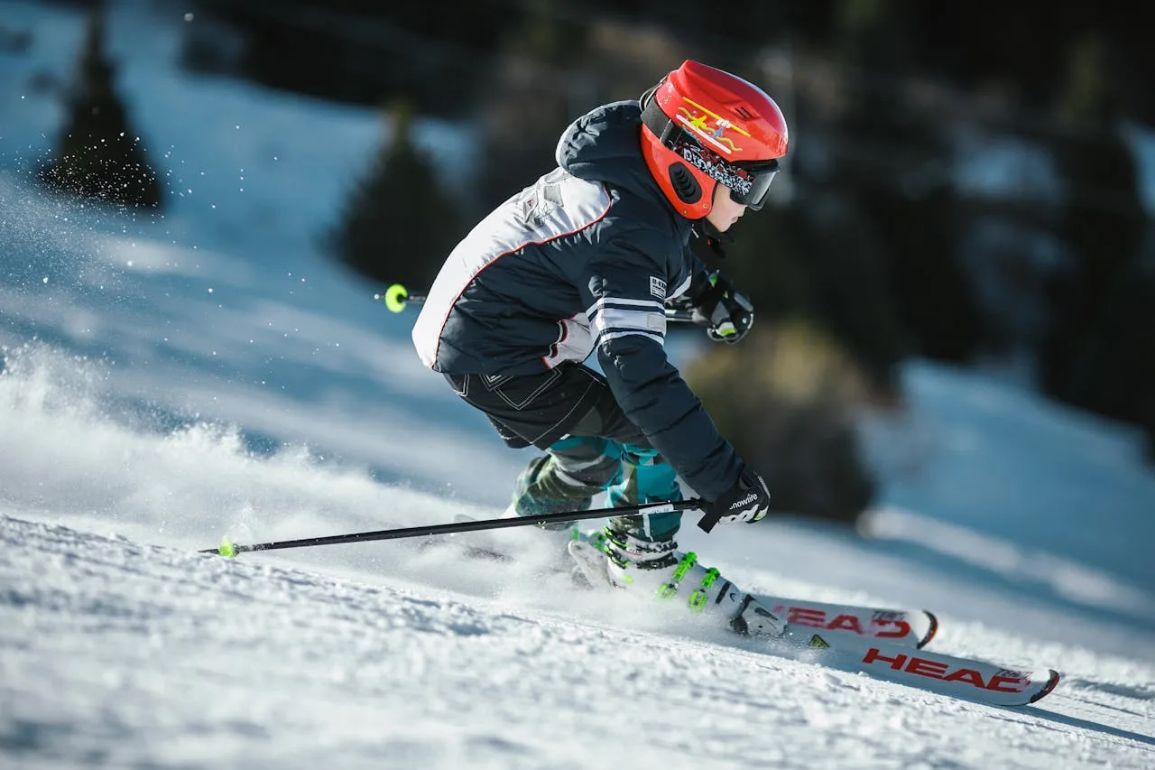 young boy skiing down a snowy mountain slope
