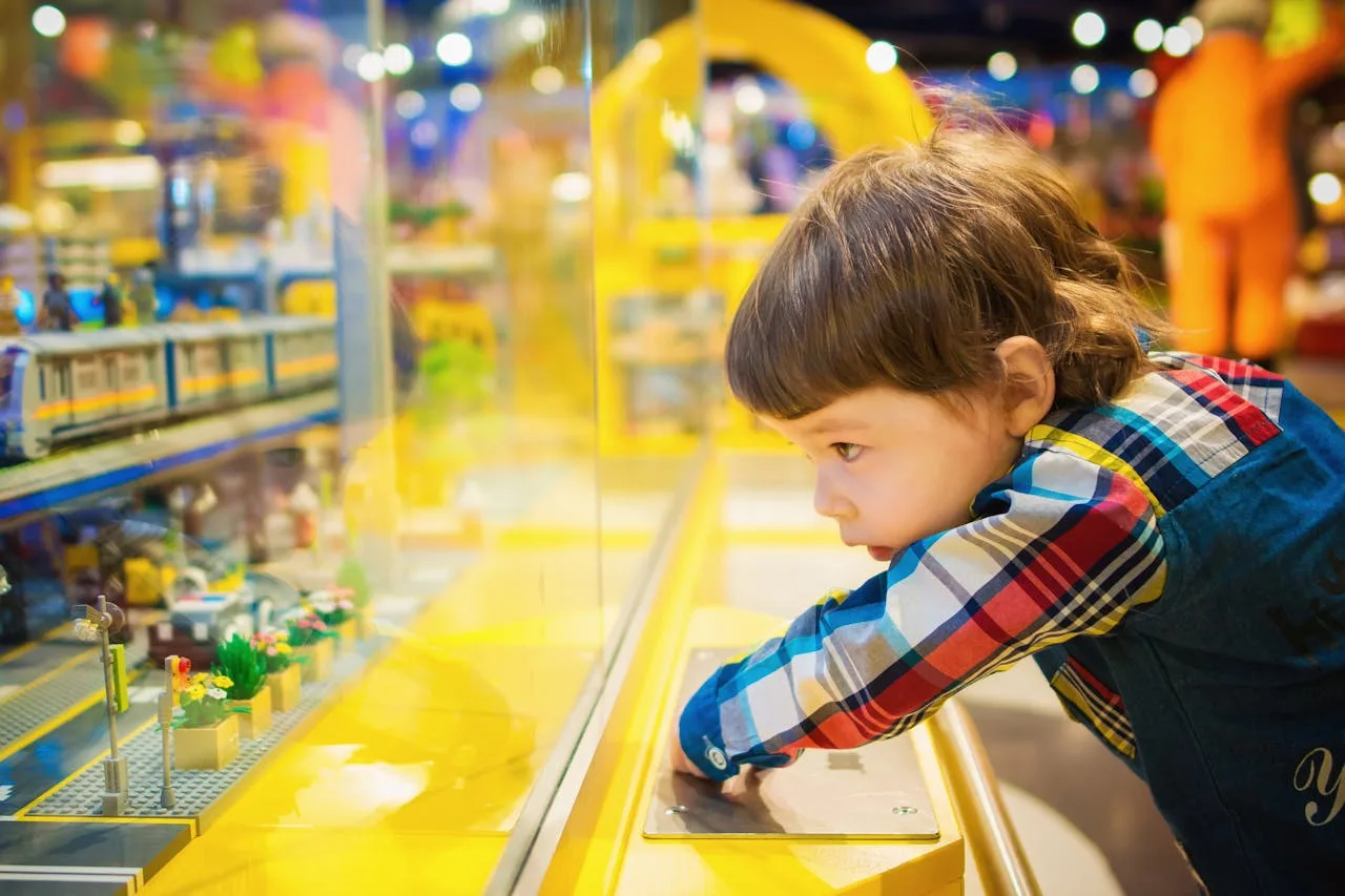 young child excitedly looking at toys in a bright toy store