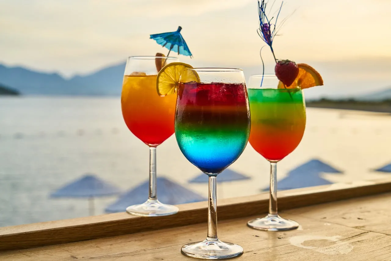 colorful cocktails on a sandy beach with ocean waves in the background