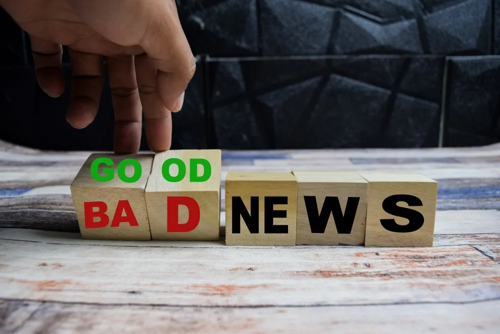 hand flips word cubes showing good or bad news concept