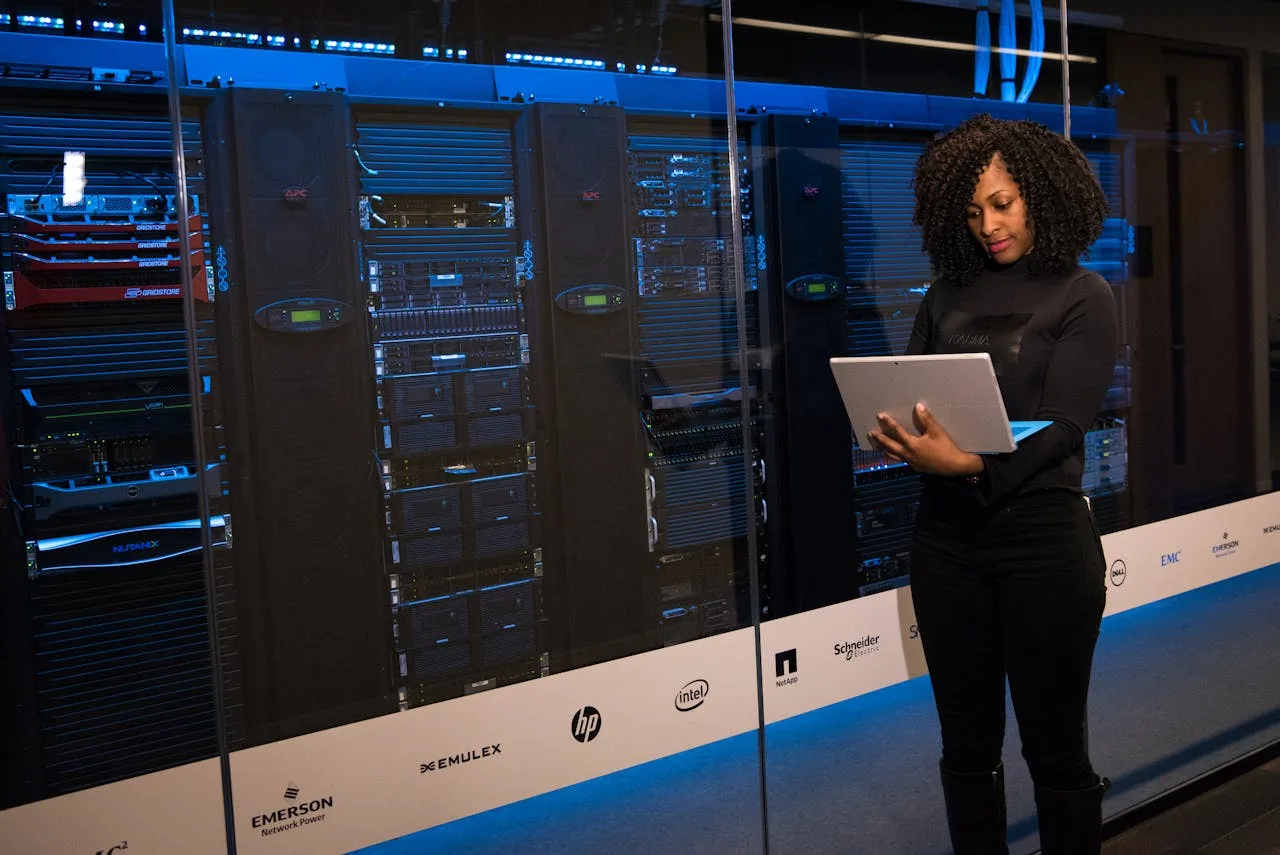 woman in cybersecurity standing in front of glowing server racks