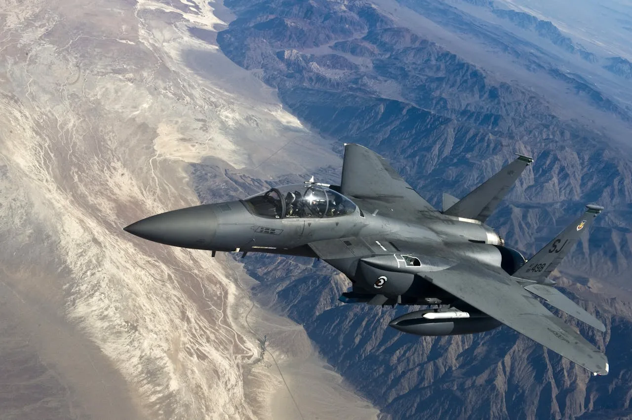f15 fighter jet flying over majestic mountain peaks