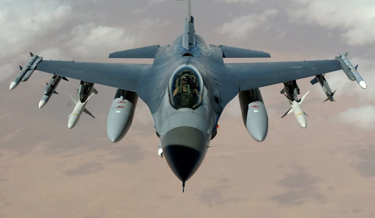 f16 fighter jet in flight over a clear blue sky