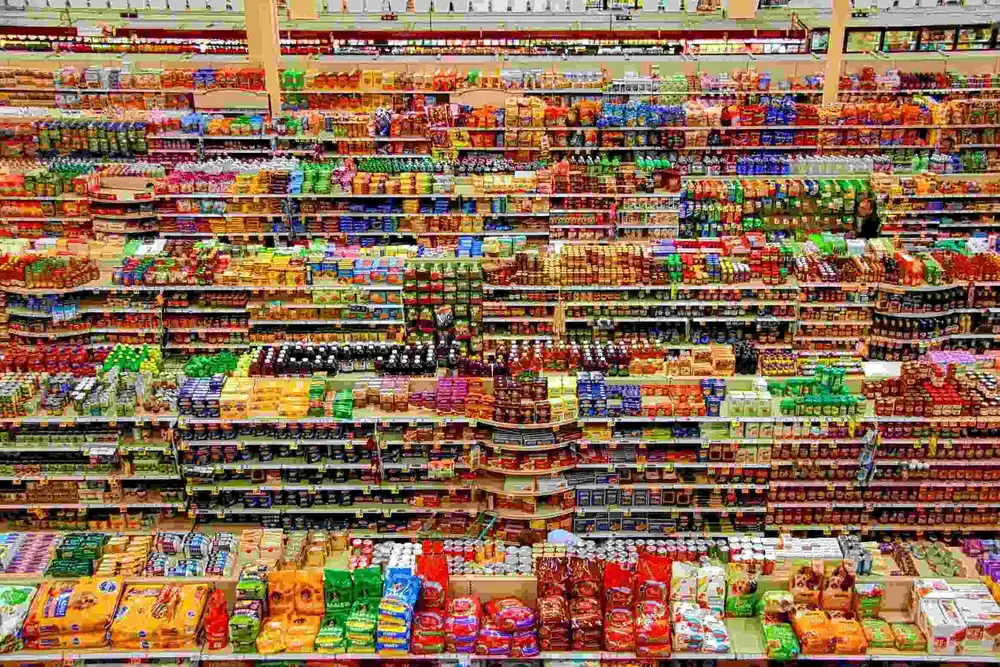 rows of grocery shelves filled with various food products and supplies