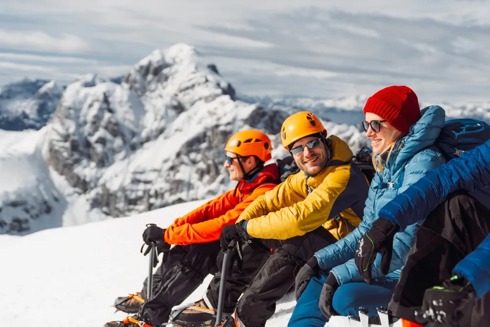 group of mountaineers sitting in the sun on a mountain top