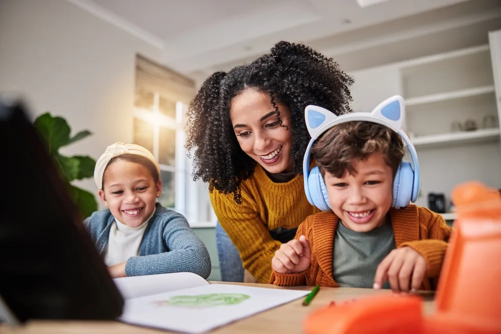 mother and children smiling while doing homework education and happiness