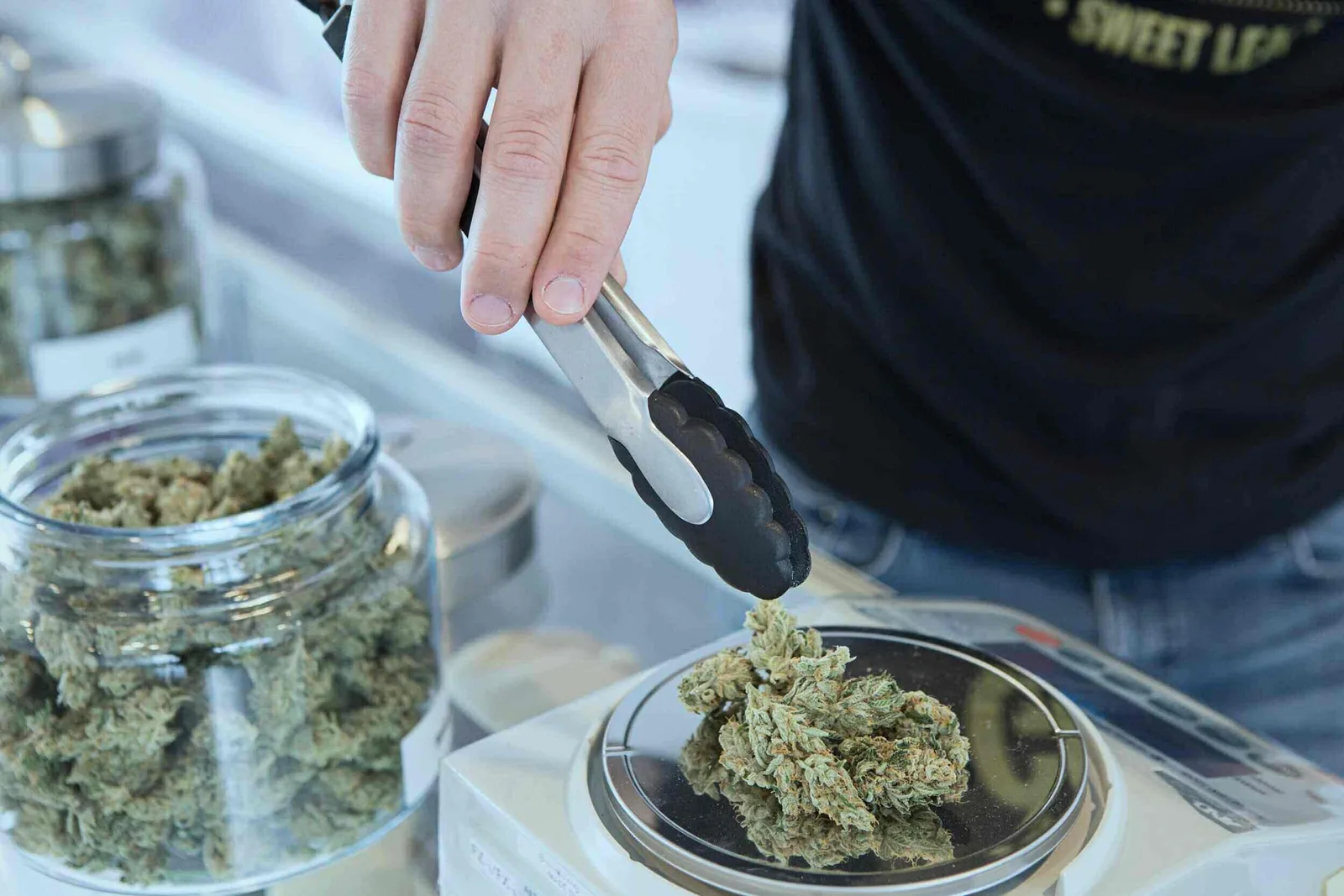 legal weed dispensary storefront with signage and cannabis products displayed inside