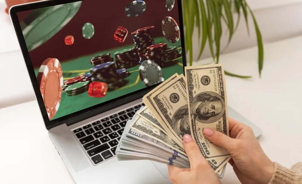 man betting on sports using laptop at table closeup bookmaker