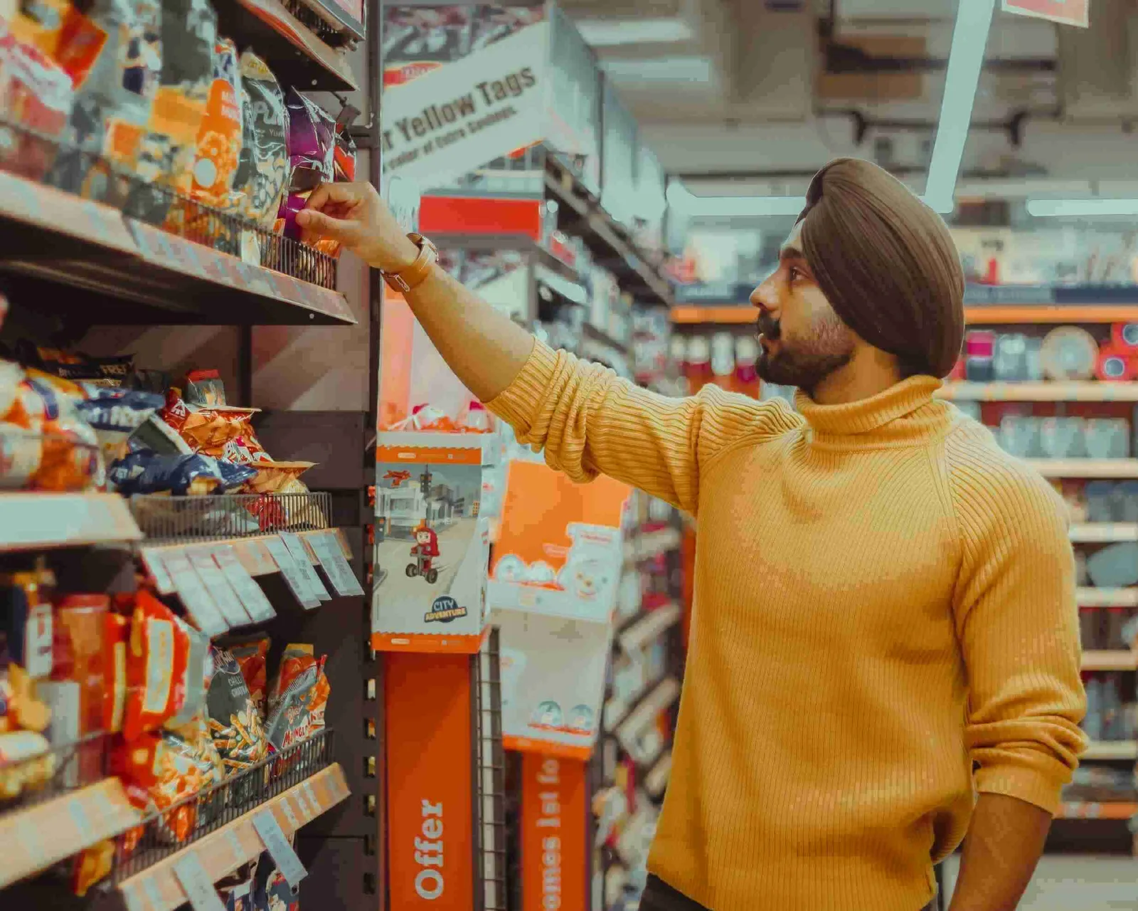 man selecting snacks in a supermarket aisle