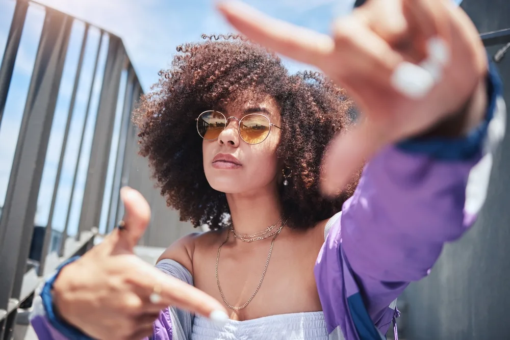 woman in fashion portrait with hands in frame in city