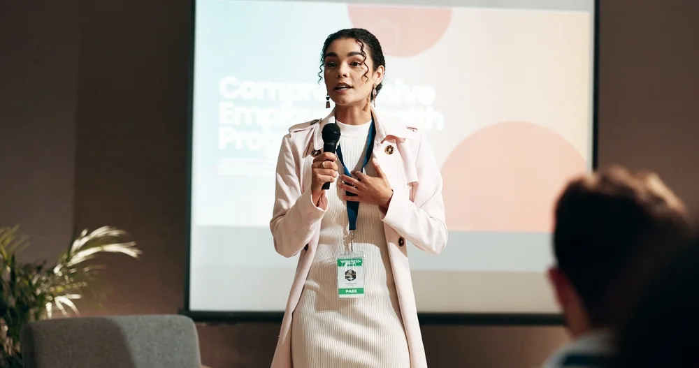 woman talking at a conference with a microphone giving a speech
