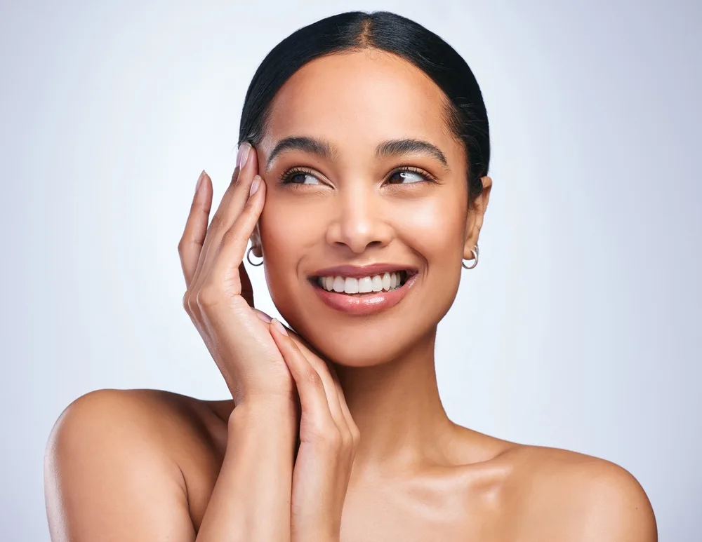 woman thinking about clean skincare in a studio healthy hands