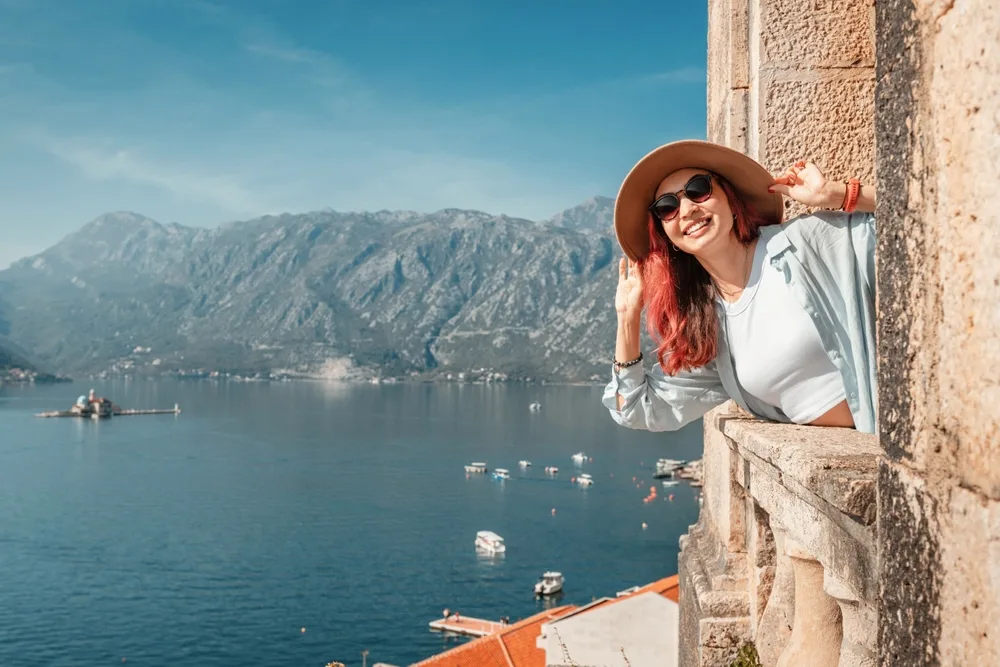 young woman with hat and sunglasses enjoying panoramic view